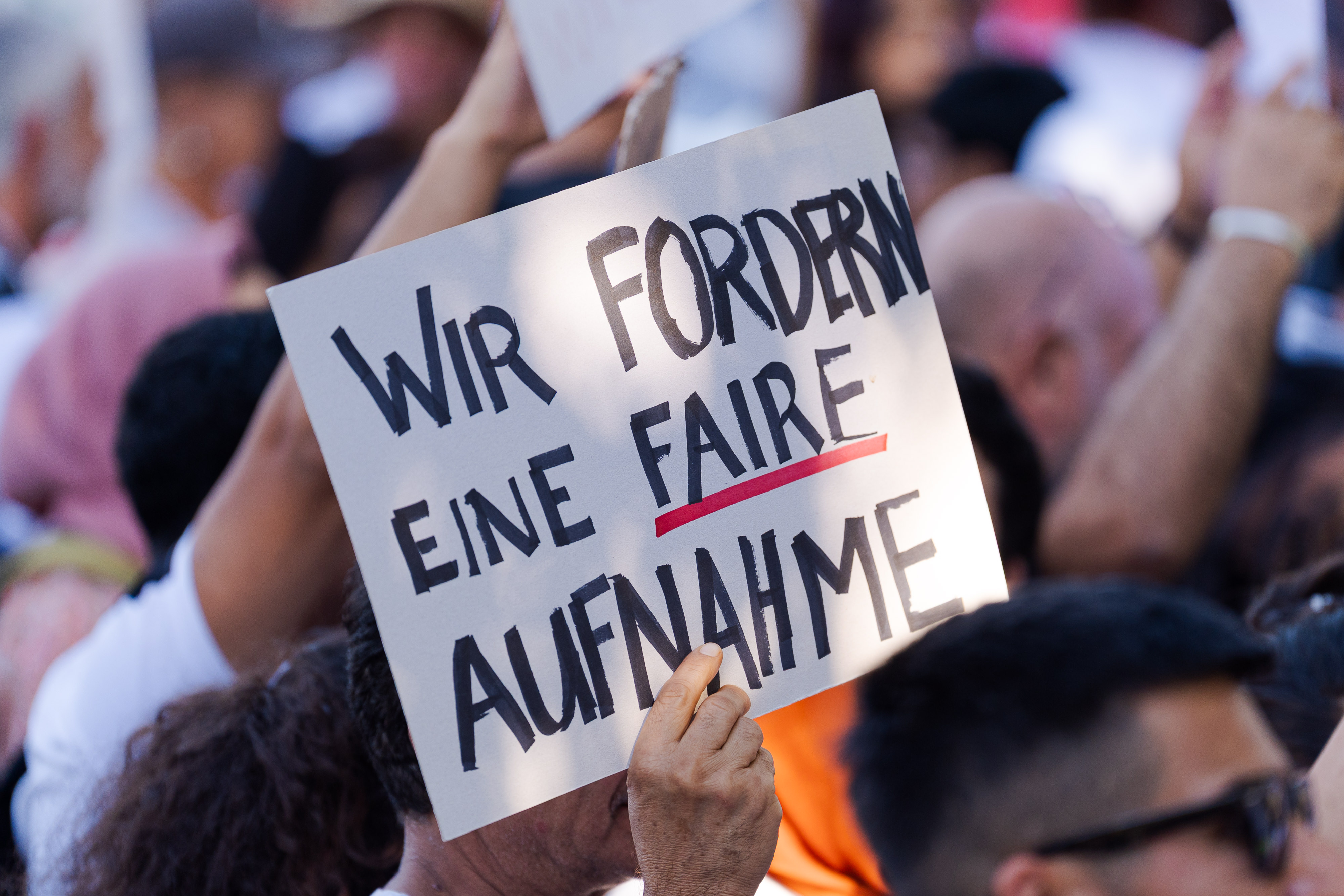 Panneau "Wir fordern eine faire Aufnahme"